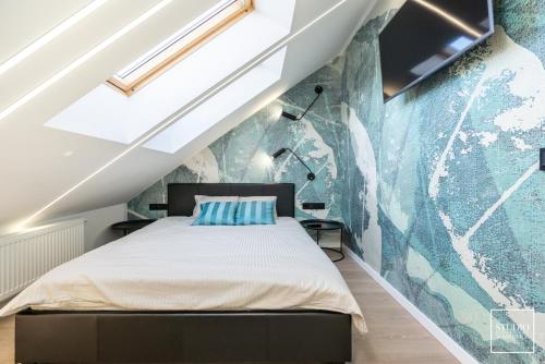 1 dormitorio con 1 cama y un mural en la pared en Apartamenty Premium Wadowice en Wadowice