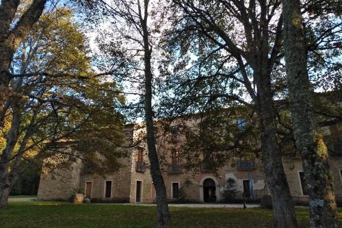an old stone building with trees in the foreground at Torre Camigliati Dimora Storica in Camigliatello Silano