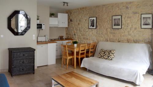 a kitchen and a living room with a couch and a table at Appartement clair et lumineux au centre de Paris in Paris