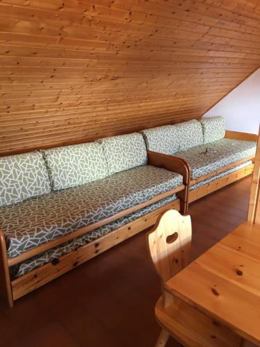 un divano in camera con soffitto in legno di MONOLOCALE MANSARDA Prato Valentino a Teglio