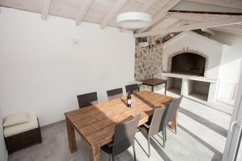 ein Esszimmer mit einem Tisch, Stühlen und einem Kamin in der Unterkunft Villa Zrinka **** in Svinišće