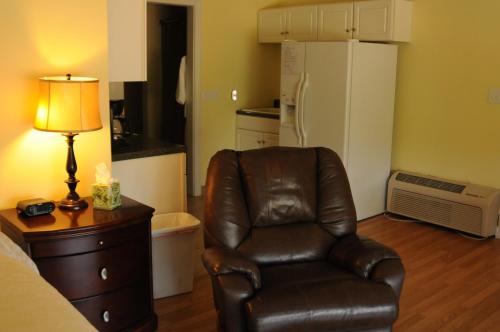 a living room with a brown leather chair and a lamp at Acorn Hill Lodge and Spa in Lynchburg