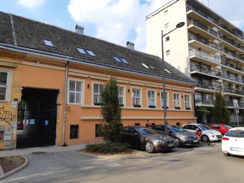 a building with cars parked in a parking lot at Arhiv Boutique House in Novi Sad