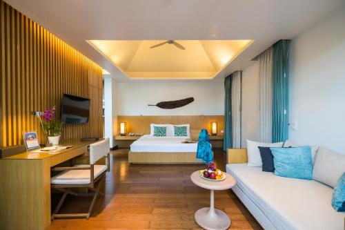 a hotel room with a bed and a couch at Chaweng Regent Beach Resort in Chaweng