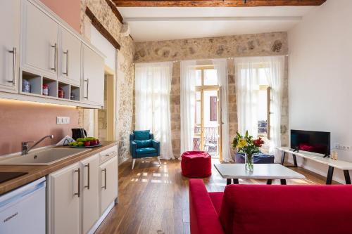 レティムノ・タウンにあるCasa Del Mareのキッチン、リビングルーム(赤いソファ、テーブル付)