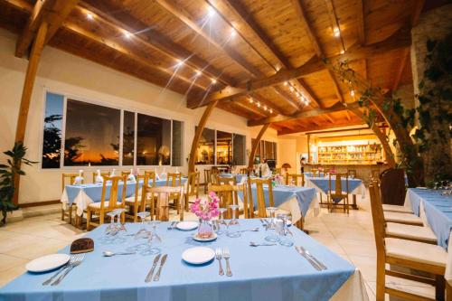 une salle à manger avec des tables, des chaises et un chiffon bleu dans l'établissement Moringa Hotel, à Toliara