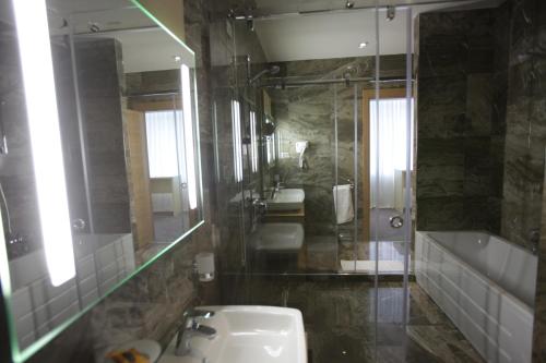 a bathroom with a sink and a toilet and a mirror at Best Western Premier Ark Hotel in Tirana