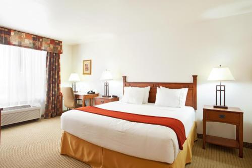 a hotel room with a large bed and a window at Holiday Inn Express Hotel & Suites Mattoon by IHG in Mattoon