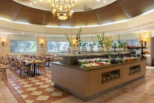 a restaurant with tables and chairs and a buffet at Ein Gedi Kibbutz Hotel in Ein Gedi