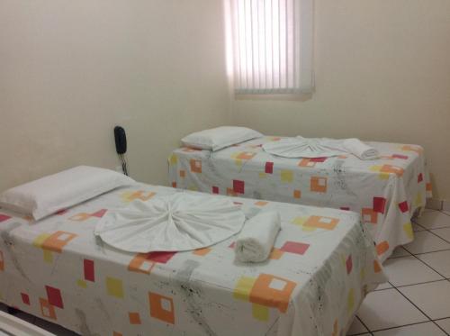two twin beds in a room with at Hotel Casa Blanca in Mossoró