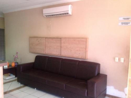 a living room with a brown couch and a air conditioner at Hotel Casa Blanca in Mossoró