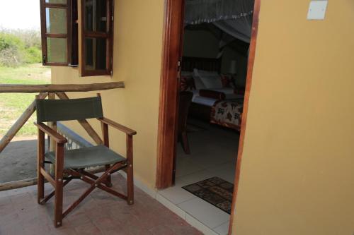 a chair sitting on the porch of a room at Engiri Game Lodge and Campsite in Katunguru