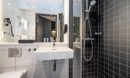 a white bathroom with a sink and a shower at Thon Hotel Linne in Oslo