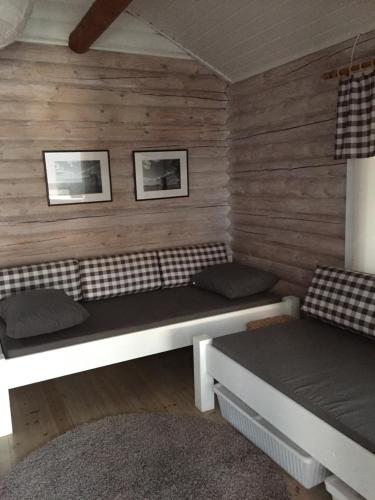 due letti in una stanza con pareti in legno di Kesäpesä ad Artjärvi