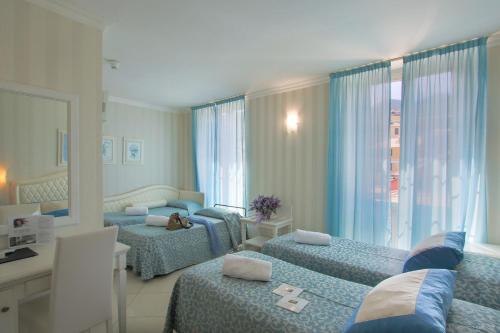 1 dormitorio con 2 camas individuales y espejo en Hotel Nazionale en Levanto