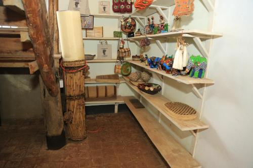 a room with shelves with various items on them at Engiri Game Lodge and Campsite in Katunguru