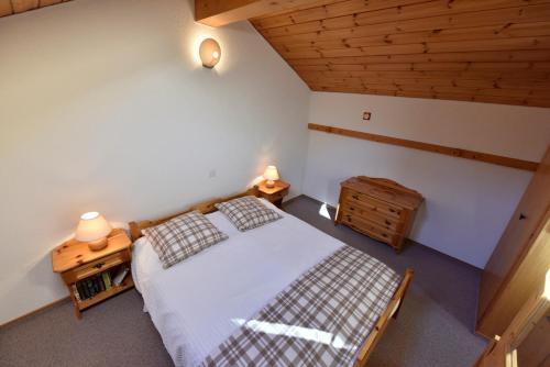 a bedroom with a bed and a wooden ceiling at Résidence Tarcianne in Grimentz