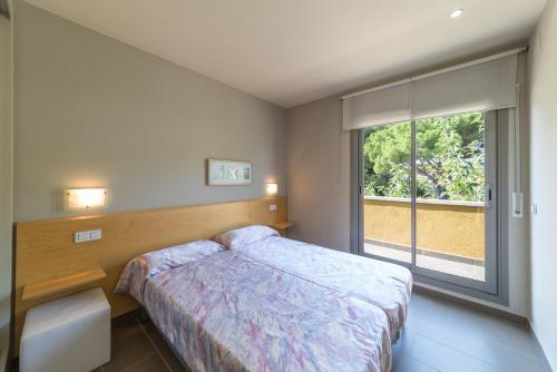 a bedroom with a bed and a large window at Villa Alegria in L'Escala