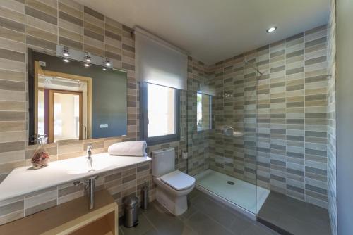 a bathroom with a toilet and a sink and a tub at Villa Alegria in L'Escala