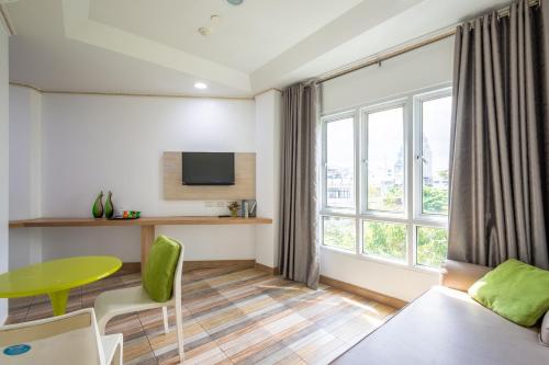a living room with a table and a green table at For You Residence in Bangkok