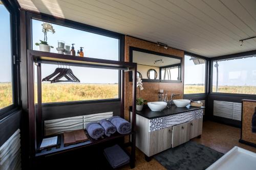 a bathroom with two sinks and a large window at The Namushasha River Villa in Kongola