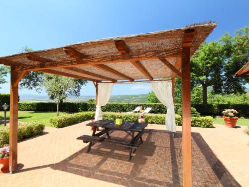a wooden pergola with a picnic table on a patio at Holiday Home Poggiolo by Interhome in Roccastrada