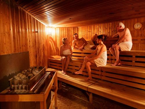 a group of people sitting in a sauna at Hotel Nordseeküste by Center Parcs in Tossenserdeich