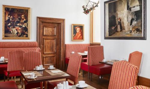a restaurant with tables and chairs and a painting on the wall at Living Hotel De Medici in Düsseldorf