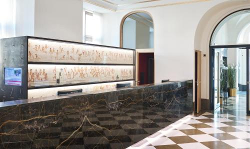a lobby of a building with a painting on the wall at Living Hotel De Medici in Düsseldorf