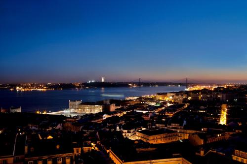 a city at night with a view of the water at Solar Dos Mouros in Lisbon