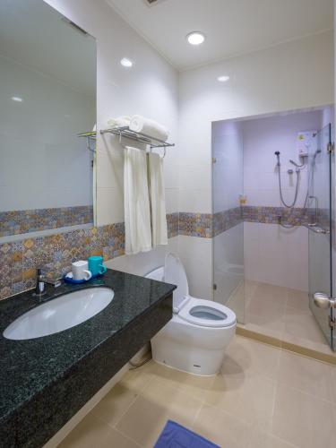 a bathroom with a toilet and a sink and a shower at For You Residence in Bangkok