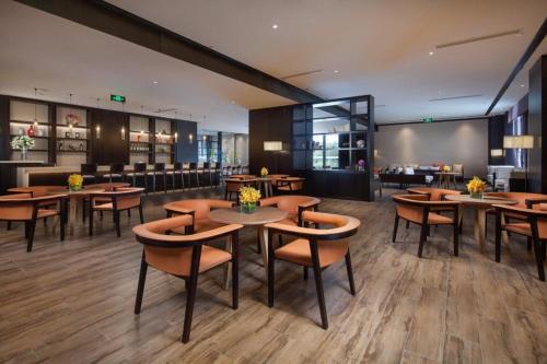 a restaurant with tables and chairs and a bar at Ramada by Wyndham Taizhou in Tiantai