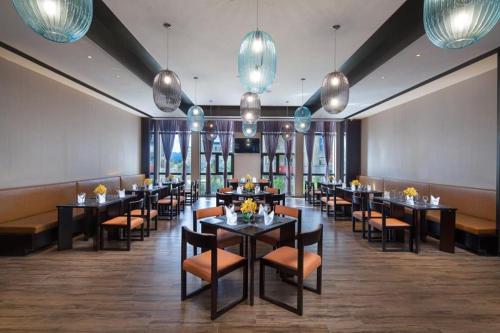 a dining room with tables and chairs and lights at Ramada by Wyndham Taizhou in Tiantai
