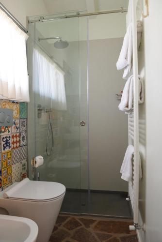 a bathroom with a toilet and a glass shower at Roccafiore Wine Resort & Spa in Todi