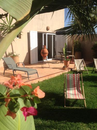 a yard with two chairs and a patio with flowers at Villa plage mirleft in Mirleft