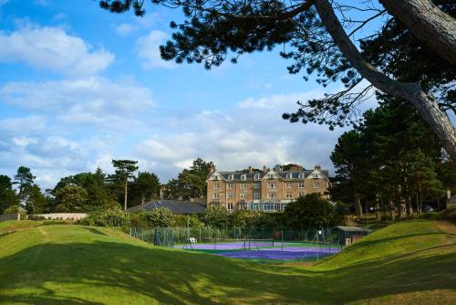 a tennis court in front of a large building at Golf View Hotel & Spa in Nairn