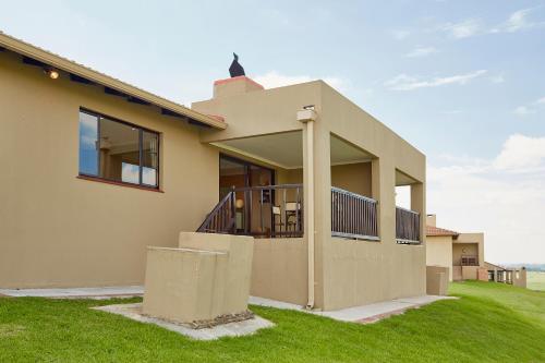 a house with a porch and a balcony at First Group Midlands Saddle and Trout in Mooirivier