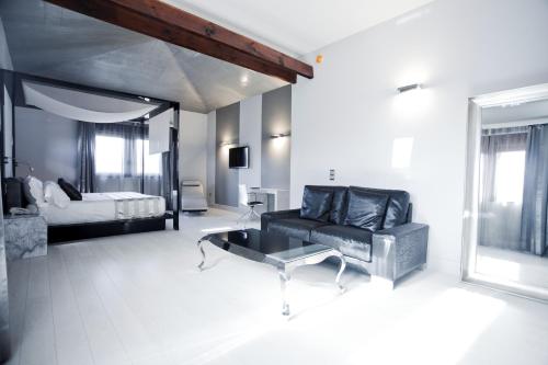 a living room with a couch and a bed at Hotel & Winery Señorío de Nevada in Villamena 