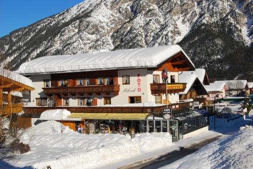 a building in the snow with a mountain at Haus Miksch in Pertisau