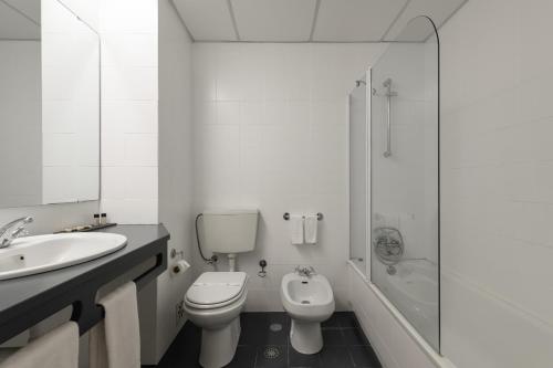 a bathroom with a toilet and a sink and a shower at Hotel Umu in Santarém