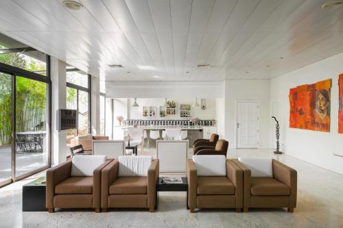 a living room with a couch and chairs and a kitchen at Hotel Umu in Santarém