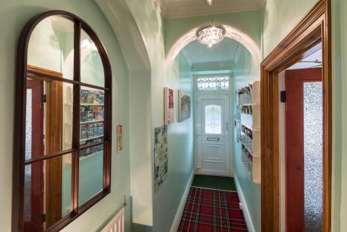 a hallway with a white door and a chandelier at DUNVEGAN in Windermere