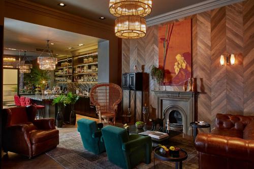 a lobby with a fireplace and chairs and a bar at Hotel Collect - Adults Only in Budapest