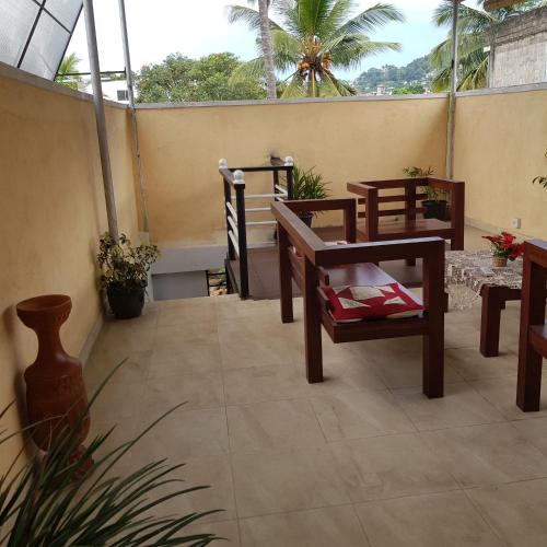 a patio with tables and chairs on a balcony at Mount View Inn in Kandy