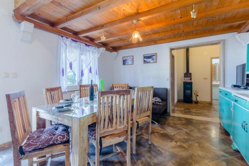 a kitchen and dining room with a table and chairs at Vila Maslinica in Pučišća