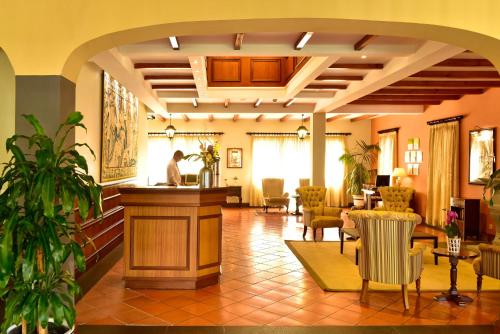 a lobby with a waiting area with chairs and a counter at Pestana Village Garden Hotel in Funchal
