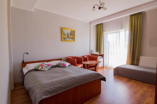 ジビジノにある11 Dębów Willa nadmorskaのベッドルーム1室(ベッド1台、椅子、テーブル付)