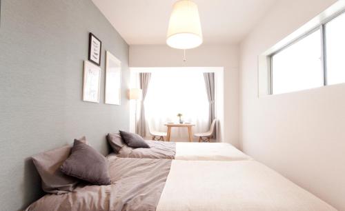 una camera con un letto e una grande finestra di Guest House Re-worth Yabacho1 301 a Nagoya