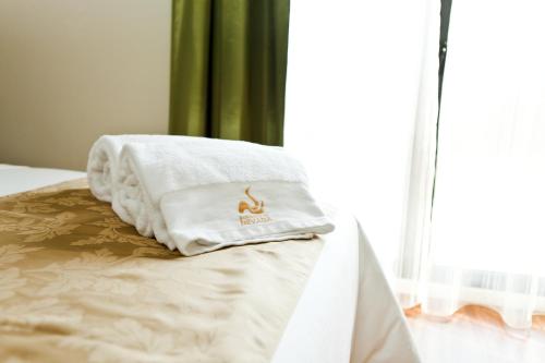 a white towel sitting on top of a bed at Hotel & Winery Señorío de Nevada in Villamena 