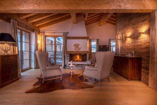 a living room with two chairs and a fireplace at Circle Chalets Arlberg in Lech am Arlberg